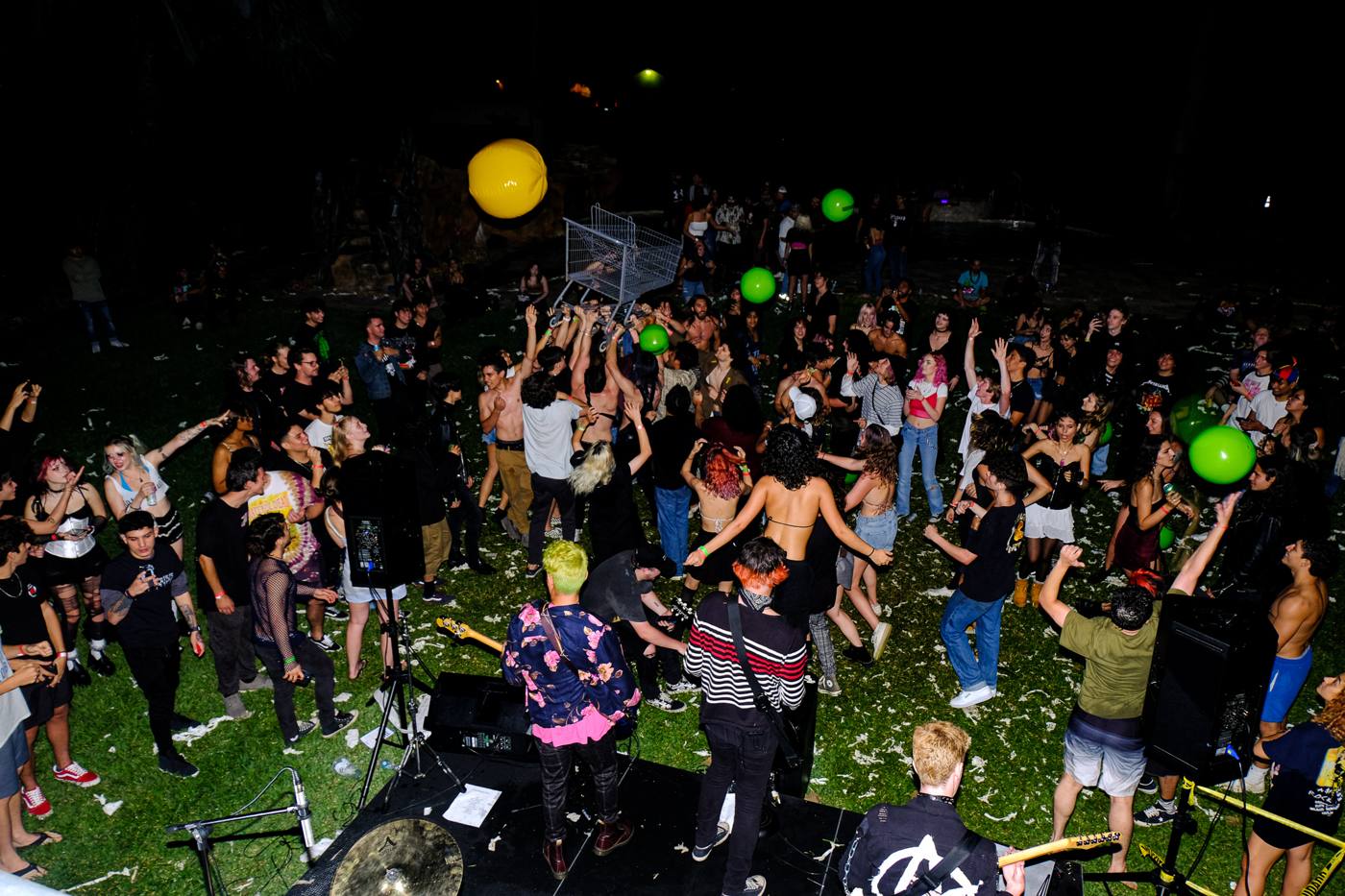 Wide shot of the crowd in front of the band with balloons flying