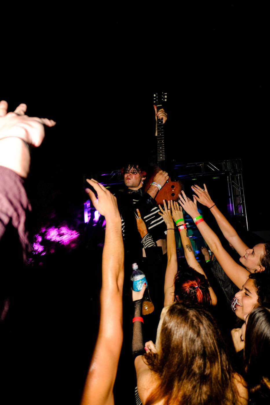 Hands reaching toward the band at night